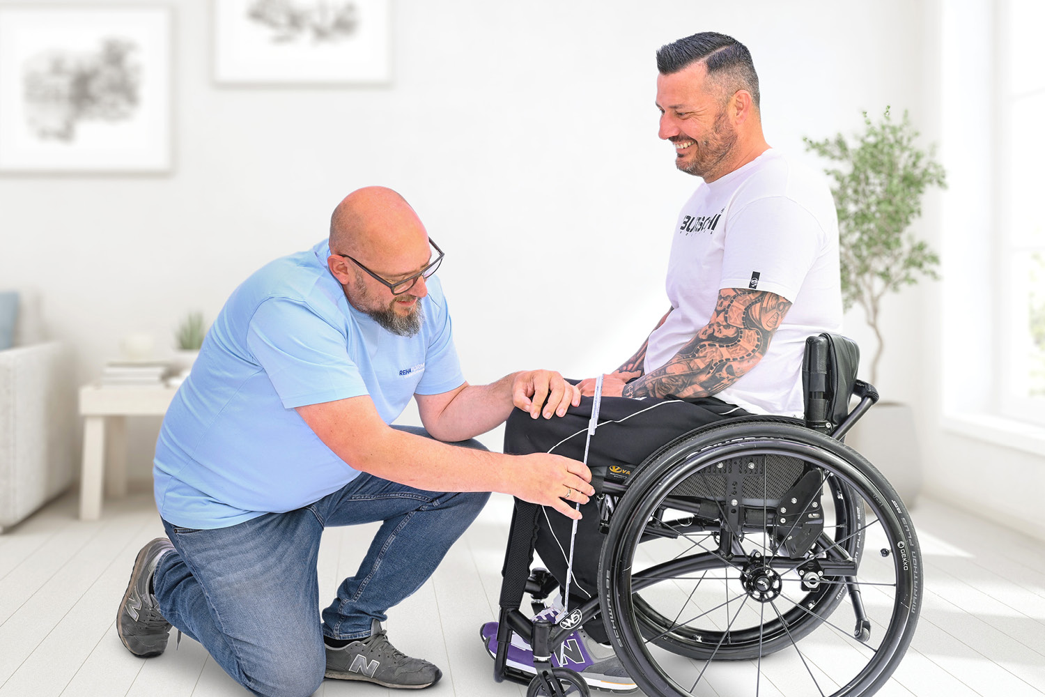 Mitarbeiter beim Ausmessen eines Kunden im Rollstuhl